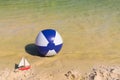 Toy boat and Inflatble beach ball floating on water Royalty Free Stock Photo