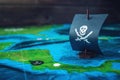 Toy boat pirate flag skull and bones on the world map of the playing field handmade Board games