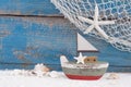 Toy boat with shells on a blue wooden background for summer, holiday, sailing concepts Royalty Free Stock Photo