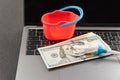 Toy bucket mop and cash dollars on laptop keyboard. Online cleaning service. Concept of money laundering online Royalty Free Stock Photo