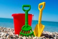 Toy bucket and spade on the beach stones Royalty Free Stock Photo