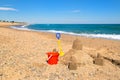 Toy buckets and sand castle at the beach Royalty Free Stock Photo