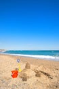 Toy buckets and sand castle at the beach Royalty Free Stock Photo