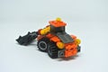 Toy bulldozer made from mostly orange and black plastic bricks.