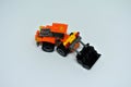 Toy bulldozer made from mostly orange and black plastic bricks.