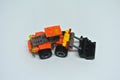 Toy bulldozer made from mostly orange and black plastic bricks.