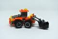 Toy bulldozer made from mostly orange and black plastic bricks.