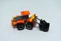 Toy bulldozer made from mostly orange and black plastic bricks.