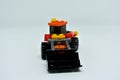 Toy bulldozer made from mostly orange and black plastic bricks.