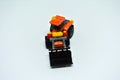 Toy bulldozer made from mostly orange and black plastic bricks.