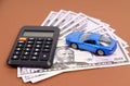 Toy car, calculator and pen on a brown background. Car rental, purchase or insurance. Royalty Free Stock Photo