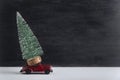 Toy car carries miniature Christmas tree. Delivery of Christmas trees concept. Copy space