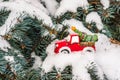 Toy car with Christmas tree on snowy branch fir Royalty Free Stock Photo