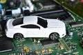 Toy car on electronic board and microchip. Conceptual image for semiconductor shortage disrupting production of the automotive