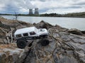 Toy car Jeep Wrangler on stones by the lake with a view of nuclear power plant