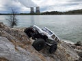 Toy car Jeep Wrangler on stones by the lake with a view of nuclear power plant