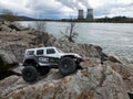 Toy car Jeep Wrangler on stones by the lake with a view of nuclear power plant