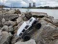 Toy car Jeep Wrangler on stones by the lake with a view of nuclear power plant