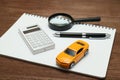 Toy car, magnifying glass, calculator, pen and notebook. Royalty Free Stock Photo