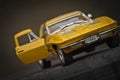 Toy car model Corvette Sting Ray 1963 year. Yellow color. Front view. Opened door. Close-up. Macro.