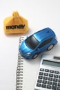 Toy car, money, calculator, and notebook Royalty Free Stock Photo