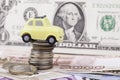 Toy car and money: dollars, rubles closeup