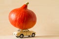 Toy car with pumpkin on roof on light background, Thanksgiving concept