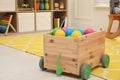 Toy car trailer with colorful balls in playroom. Interior design Royalty Free Stock Photo