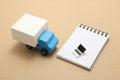 Toy car truck and miniature laptop on memo pad.