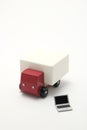 Toy car truck and miniature laptop on white background.