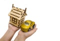 Toy car and wooden house in the hands of a man on a white background. Business concept. Real estate concept. An alternative to buy Royalty Free Stock Photo