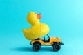 Toy car and yellow rubber duck on blue background. Summer minimal concept