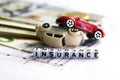 Toy cars accident damage and insurance word from tiled letter blocks