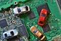 Toy cars on electronic board and microchip. Conceptual image for semiconductor shortage disrupting production of the automotive in