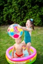 Toy for children games. Children playing with Inflatable rubber beach ball. in water pool. Summer holiday. Boy and Girl Playing in Royalty Free Stock Photo