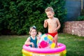 Toy for children games. Children playing with Inflatable rubber beach ball. in water pool. Summer holiday. Boy and Girl Playing in Royalty Free Stock Photo