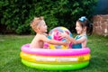 Toy for children games. Children playing with Inflatable rubber beach ball. in water pool. Summer holiday. Boy and Girl Playing in Royalty Free Stock Photo