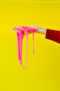 A toy for children mucus and liquid flowing on hand on a yellow background