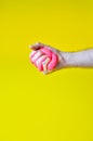 A toy for children mucus and liquid flowing on hand on a yellow background