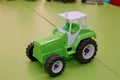 Toy for children. Toy tractor on green background . Green Tractor