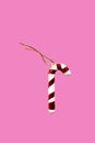 Toy Christmas candy cane lied evenly in row on pink background. Royalty Free Stock Photo