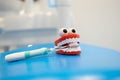 Toy clockwork jaw and a toothbrush lies on a blue dental chair in a children`s dental clinic. Royalty Free Stock Photo