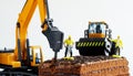 Toy construction machinery and worker with jackhammer work on chocolate biscuit cake sprinkled with chocolate chips. Concept of