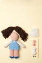 A toy crocheted, a doll in a blue dress, an unfinished work - the hair is not sewn and the decor is not executed.