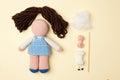 A toy crocheted, a doll in a blue dress, an unfinished work - the hair is not sewn and the decor is not executed, the tools.