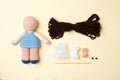 A toy crocheted, a doll in a blue dress, an unfinished work - the hair is not sewn and the decor is not executed, the tools.