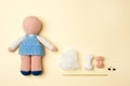 A toy crocheted, a doll in a blue dress, an unfinished work - the hair is not sewn and the decor is not executed, the tools.