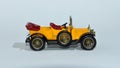 Toy diecast model of a Yellow 1911 Daimler a Matchbox yesteryear product by Lesney with white background