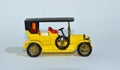 Toy diecast model of a Yellow 1907 Peugeot a Matchbox yesteryear product by Lesney with white background