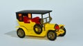 Toy diecast model of a Yellow 1907 Peugeot a Matchbox yesteryear product by Lesney with white background